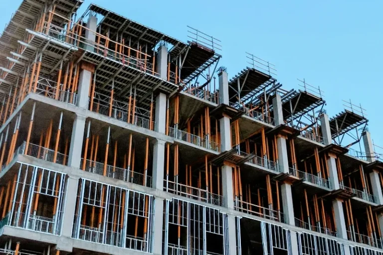 Construction site with a multi-storey building framework and scaffolding.