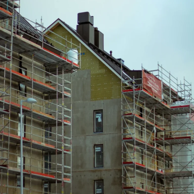 A partially constructed building surrounded by scaffolding and construction materials.