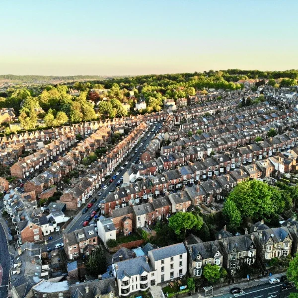 Aerial view of a residential area with rows of houses and green spaces.