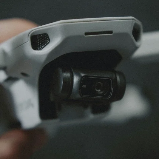 Close-up of a grey drone's camera and body, highlighting its design and lens.