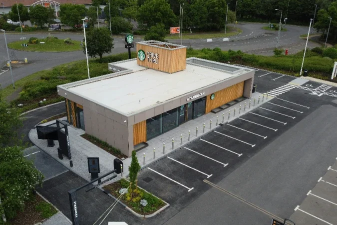 Exterior of a modern building with a wooden facade and empty parking lot.
